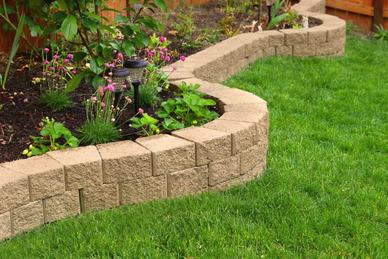 stone wall with perfect grass landscaping in garden with artific